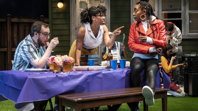 Three people talk at a party